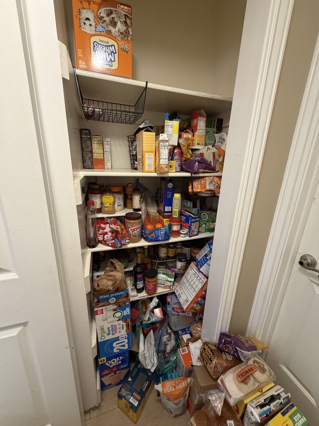 Pantry crowded with food packages before organization