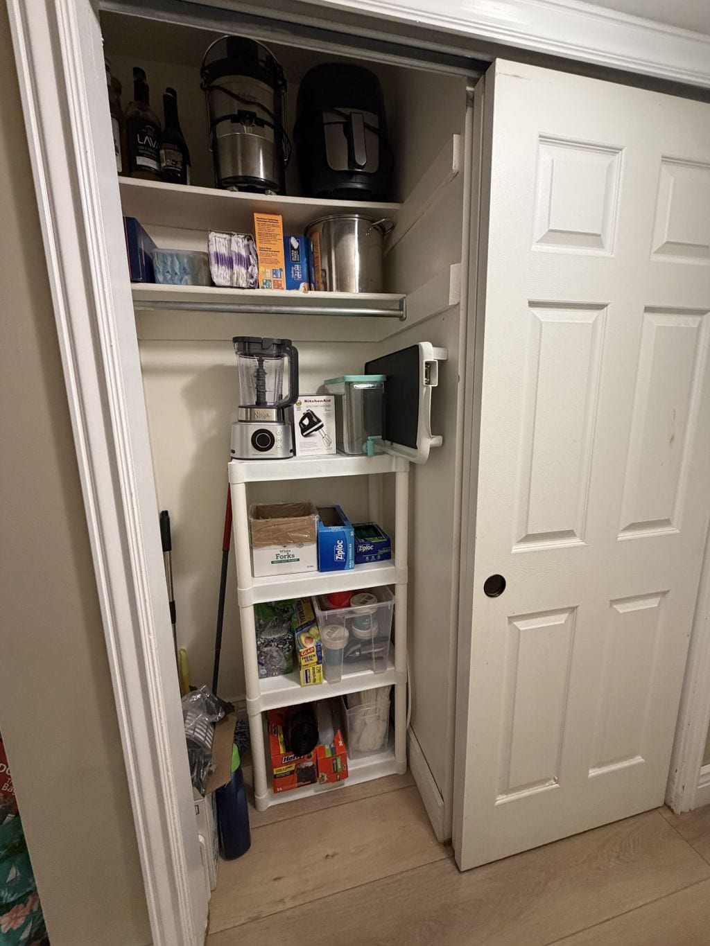Utility closet after organization with appliances grouped and floor space cleared