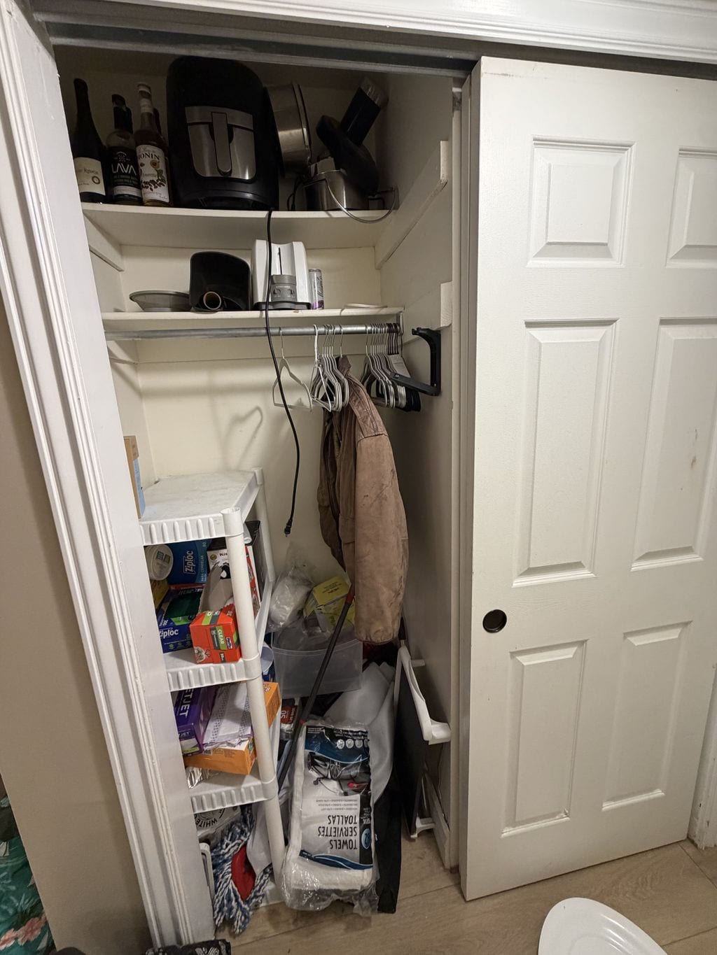 Utility closet before organization with appliances and supplies competing for space